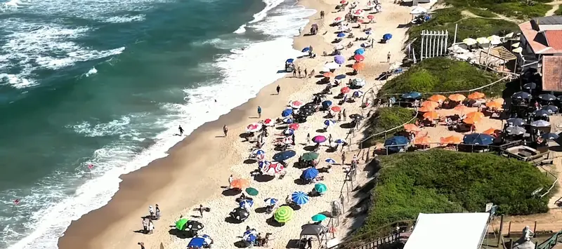 A Praia Mole vista de cima, com o mar azul e os guarda-sóis na areia
