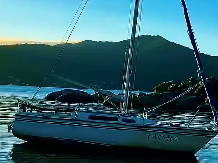 Veleiro na Lagoa da Conceição no fim de tarde, com os morros ao fundo