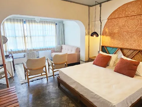 Quarto com cabeceira em mandala, almofadas terracota e sala com janelas